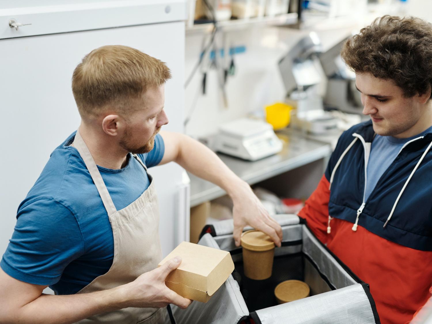 Food service staff pack food for delivery to customer