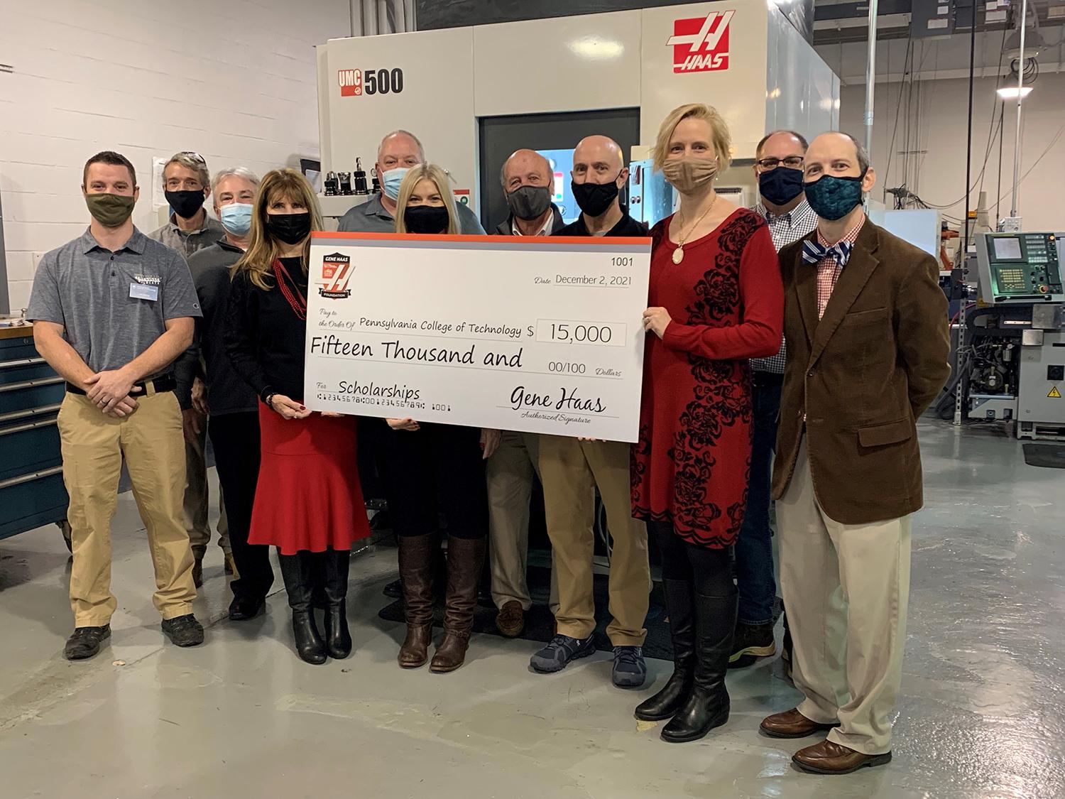 A group of people posing for a photograph and holding a giant mockup of a check