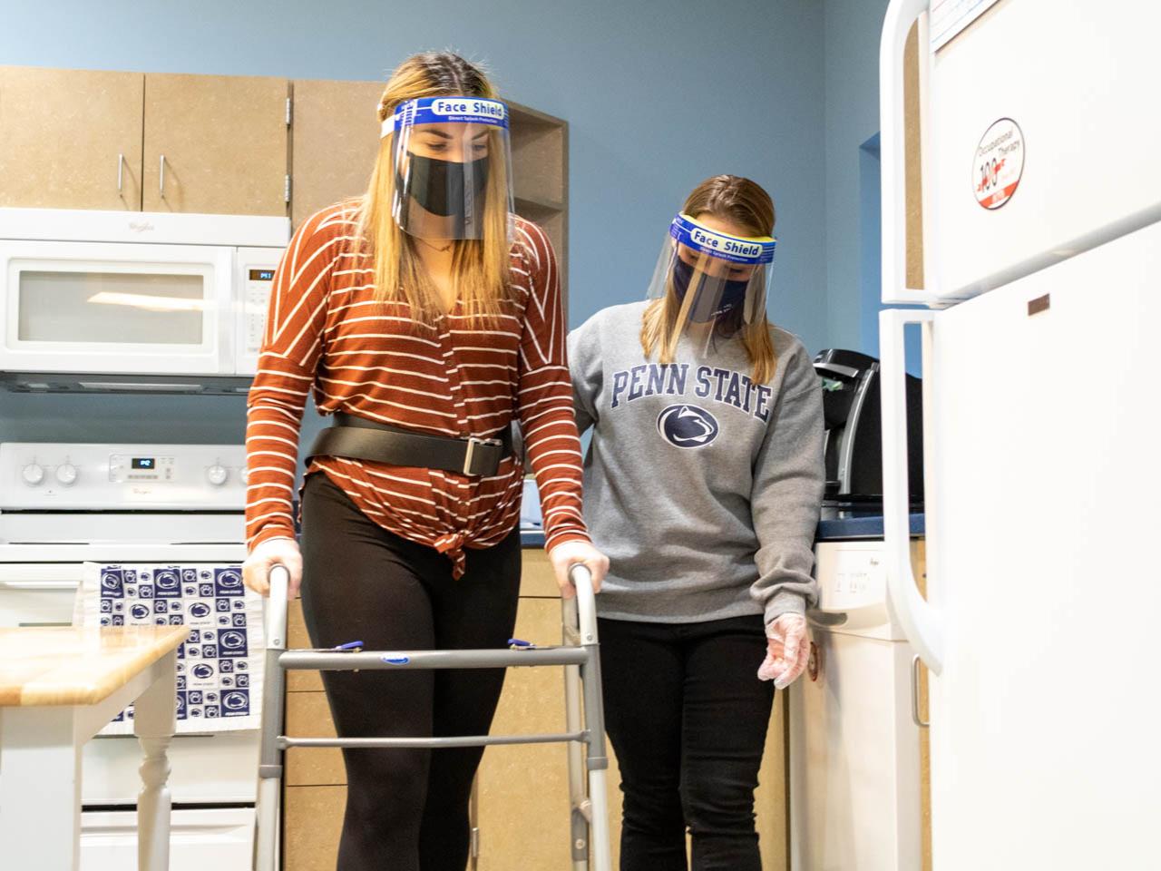 Two students use walker in kitchen