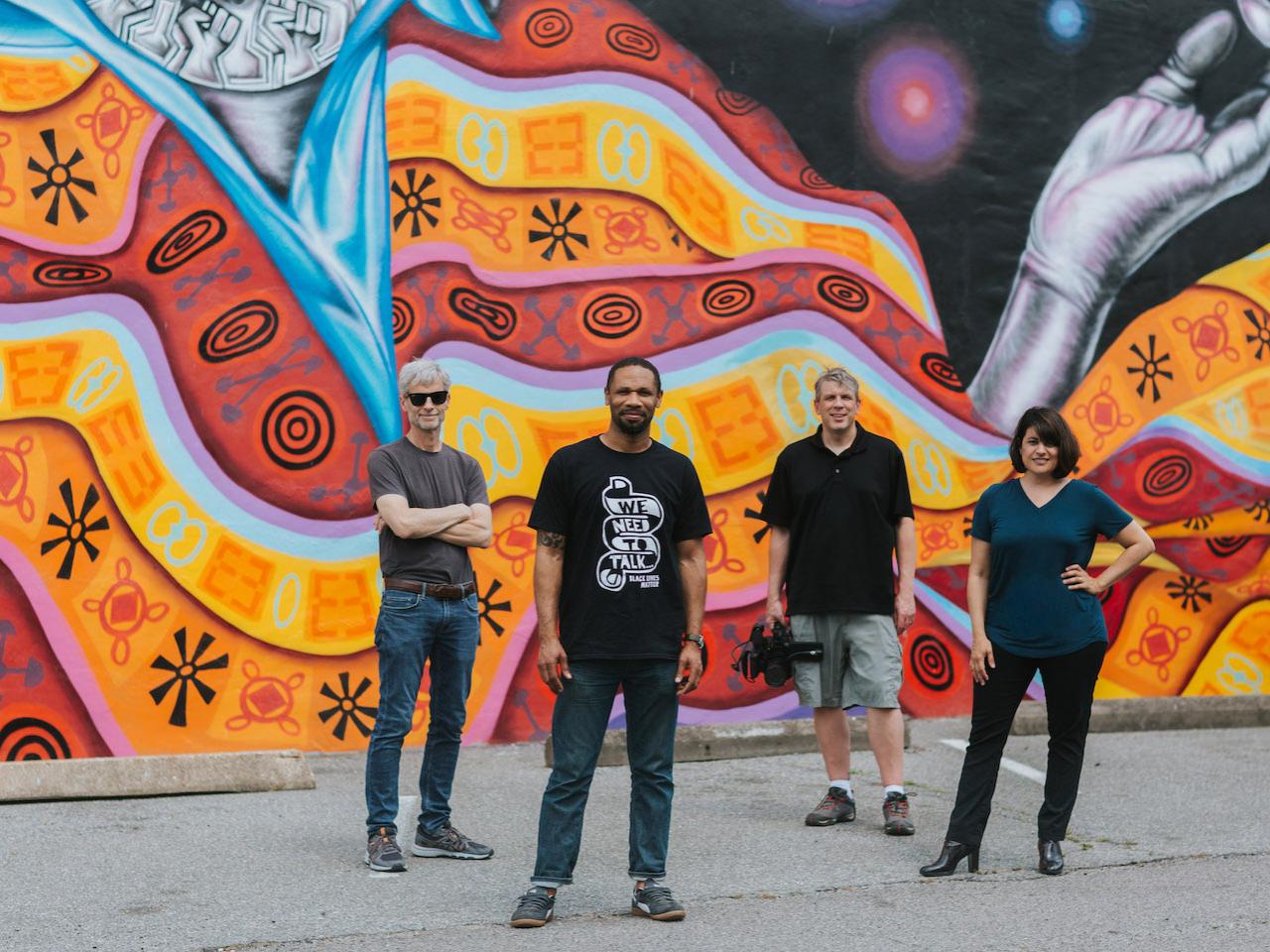 "Mending Walls" production team standing in front of mural