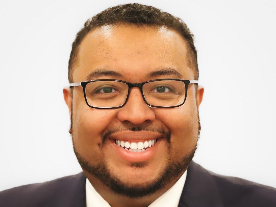 Michael Wade Smith in a dark suit with a white shirt and blue Penn State tie against a white background.