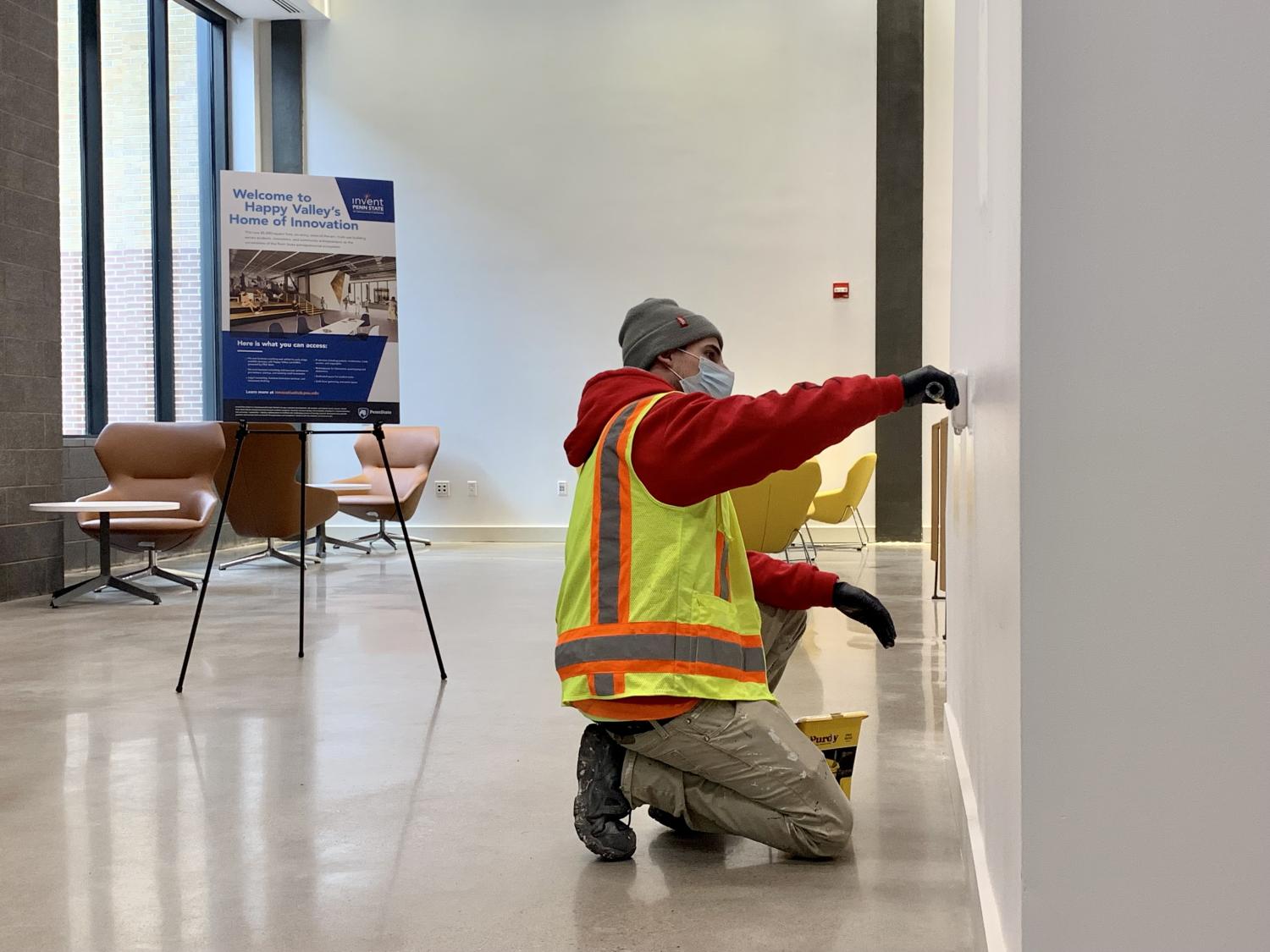 Paint Ninjas Foreman Phil Dellegrotti completing finishing paint touches on the interior white walls at the Penn State Innovation Hub