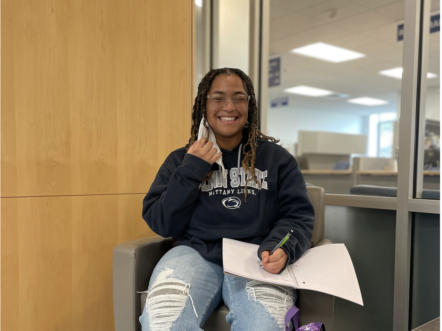 Students Sierra Coleman sits in a chair writing
