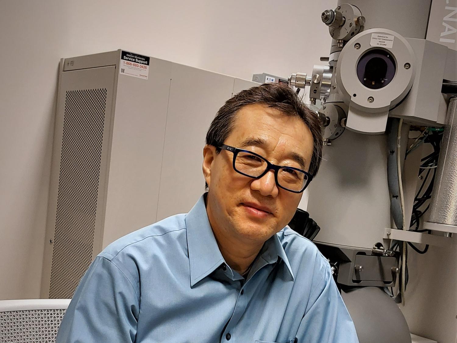 a man sits in front of a piece of scientific equipment 