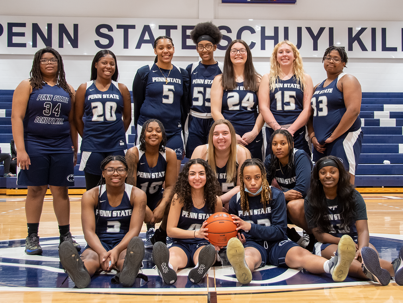 The Penn State Schuylkill women's basketball team poses at mid-court in the gymnasium.