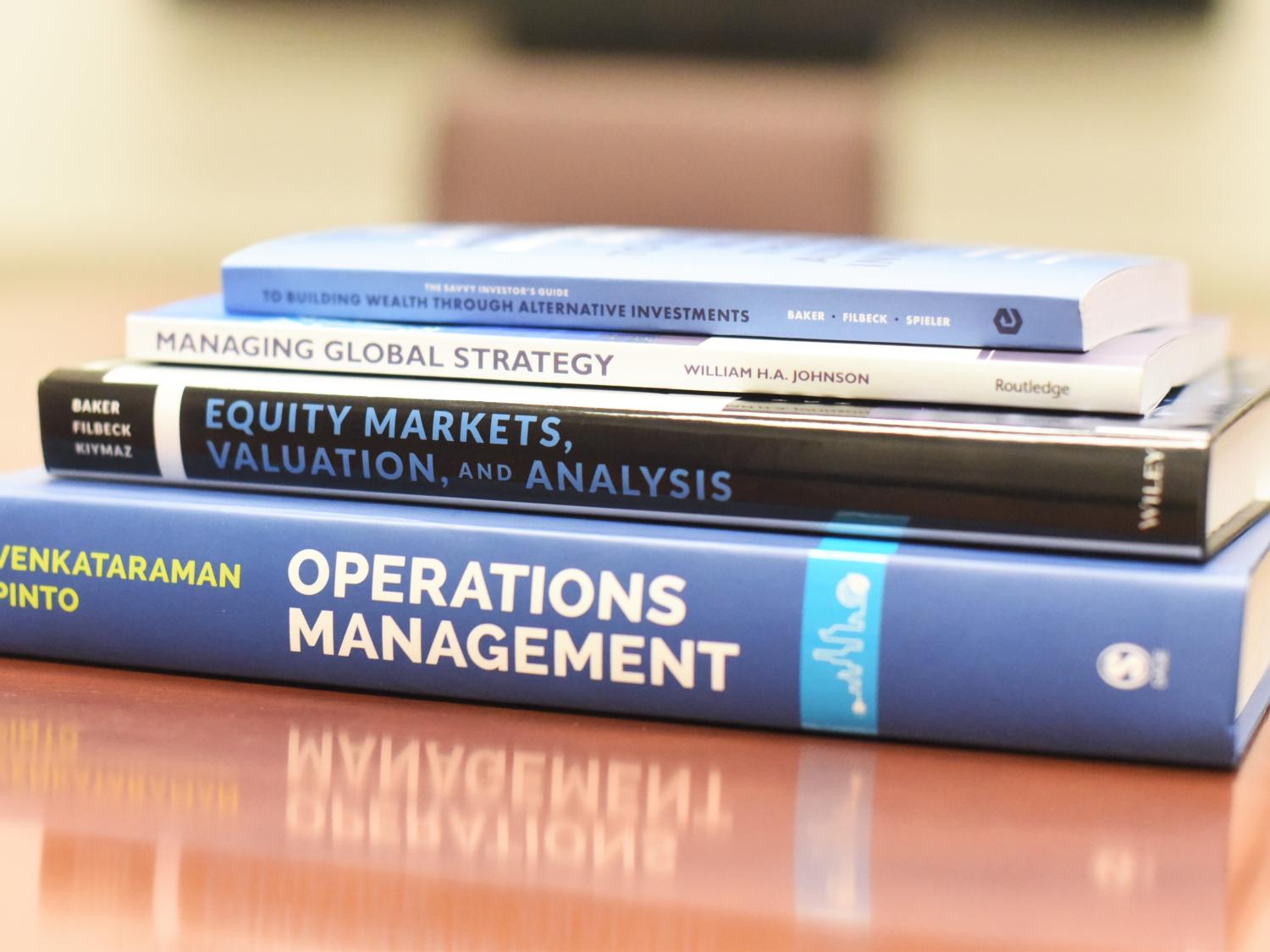 A stack of four books written or co-written by faculty members in Penn State Behrend's Black School of Business