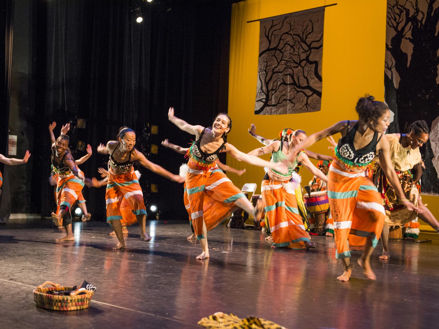 Members of the Kotchegna Dance Company dance on a stage.