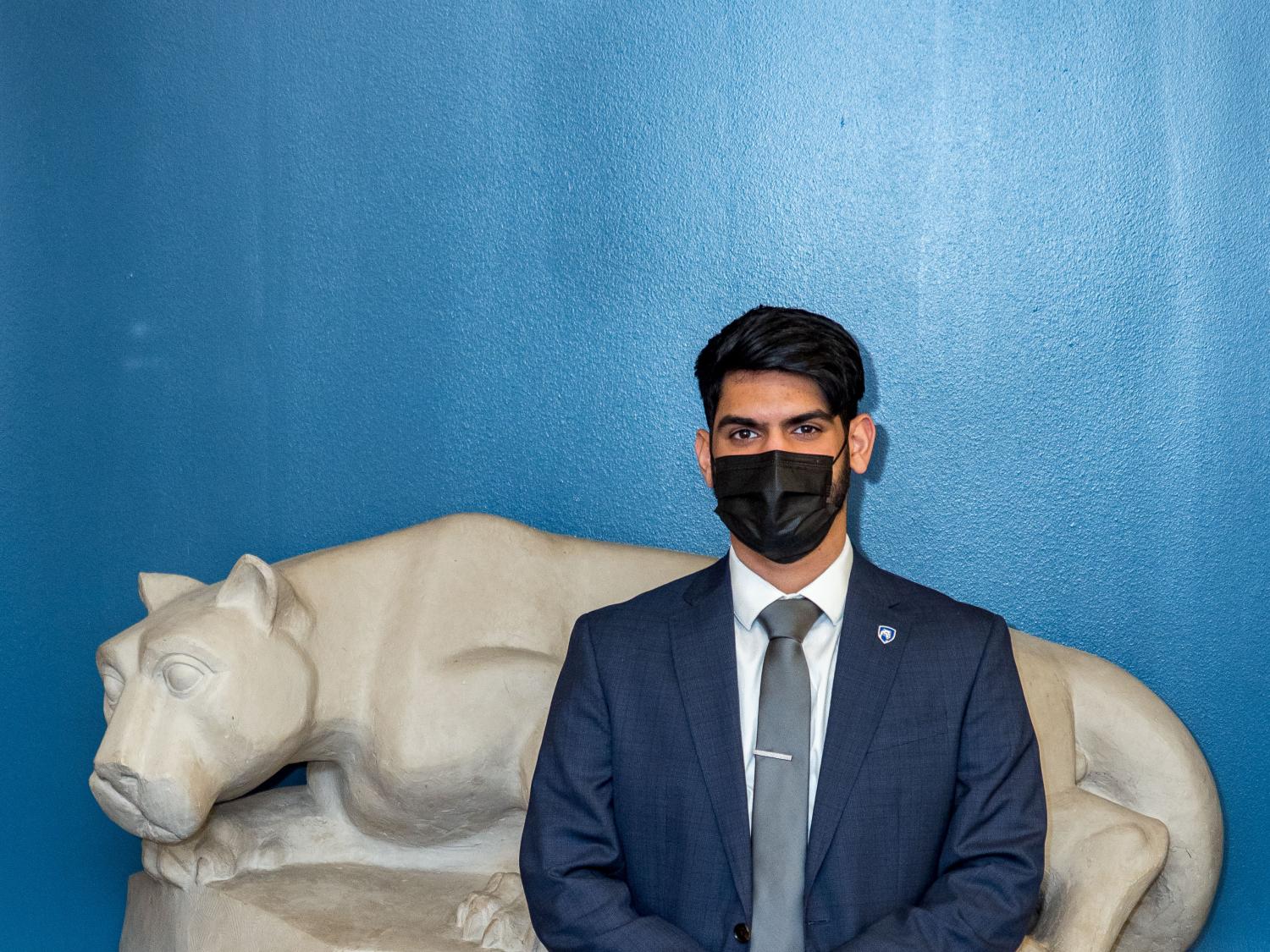 Previn Joseph standing by Nittany Lion sculpture 