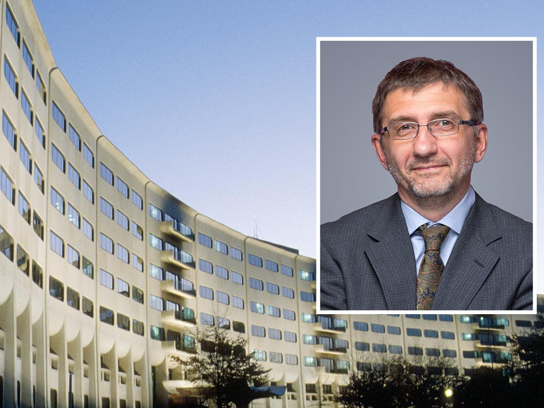 A head and shoulders professional portrait of Nikolay Dokholyan against a background image of Penn State College of Medicine.