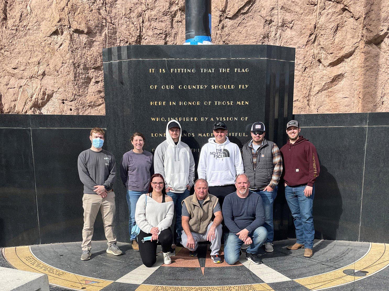 A group of students pose for a photo at a conference at Hoover Dam.