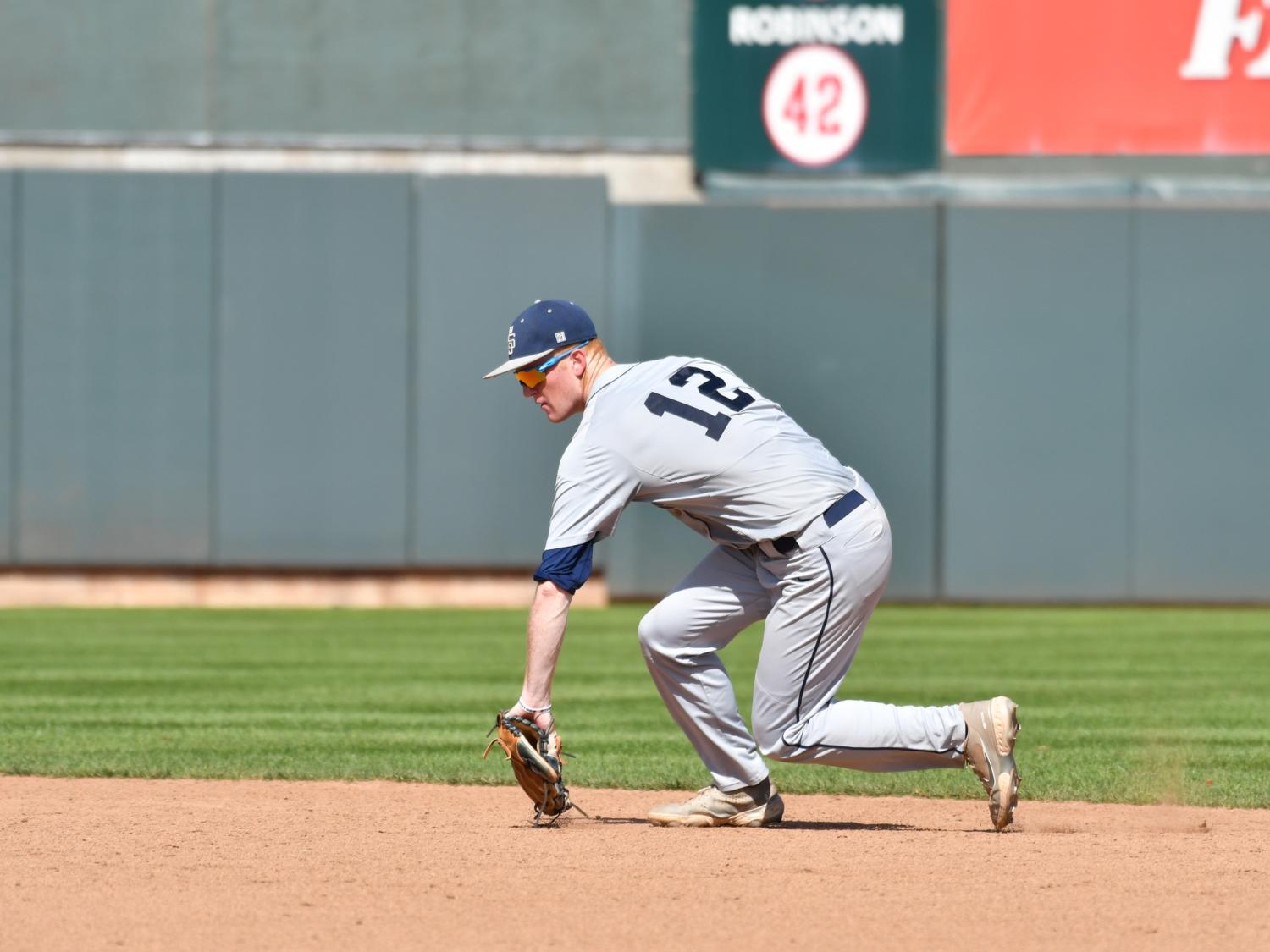 A Penn State Behrend baseball player stops a ground ball in the infield.