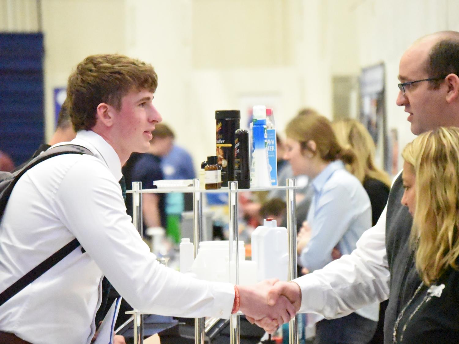 A student shakes hands with a recruiter at Penn State Behrend's spring Career and Internship Fair.