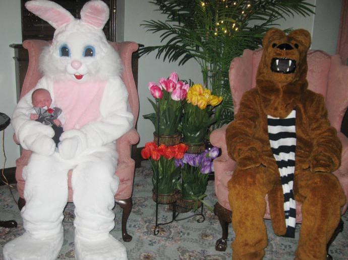 Easter bunny holding a baby and seated in a chair next to Nittany Lion