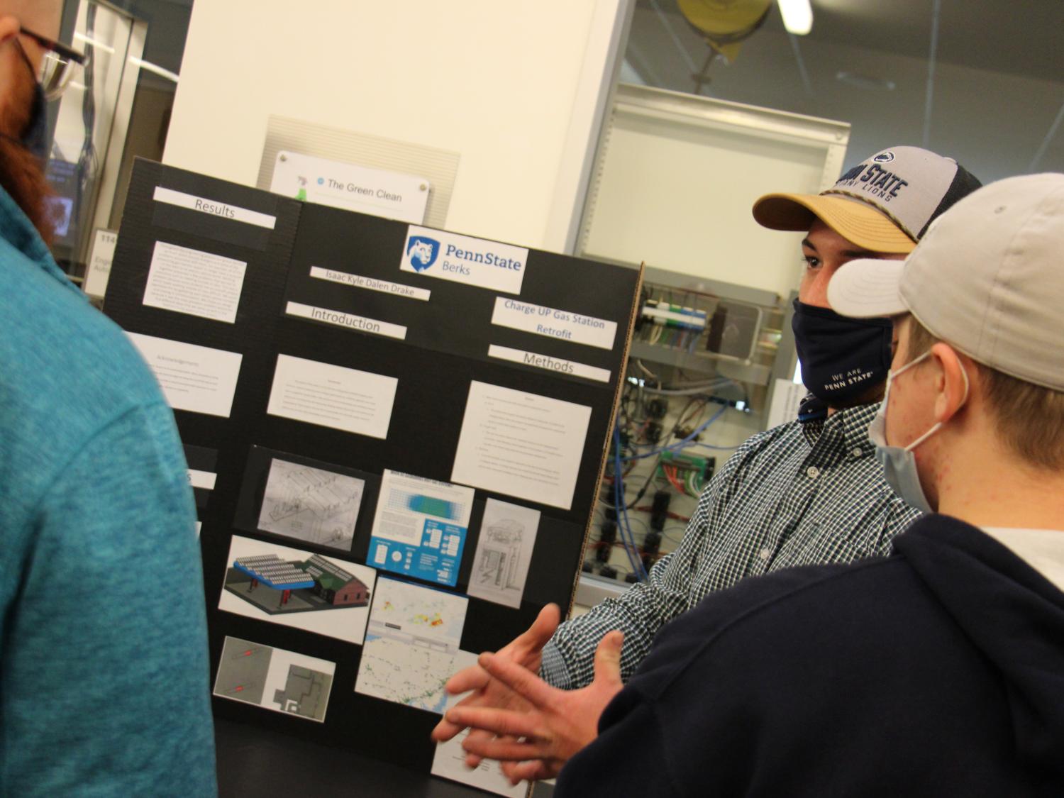 The winning posterboard submission from the Engineering Design competition, surrounded by the team of students