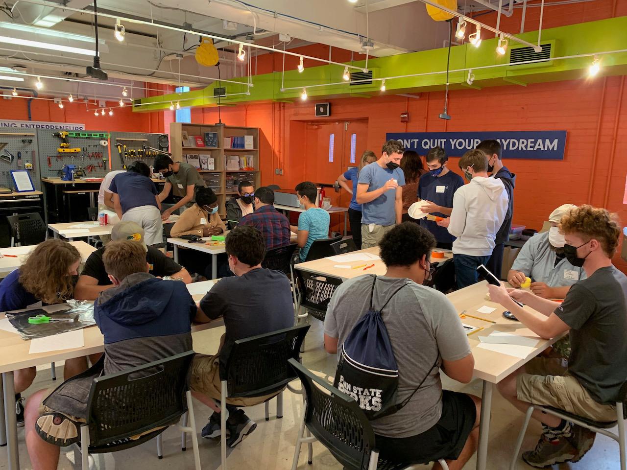 Participants work at tables in the Launchbox