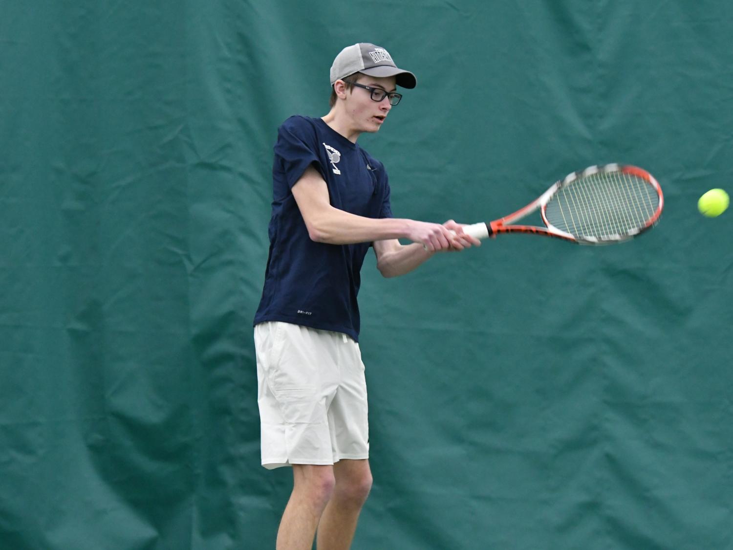 A Penn State Behrend tennis player hits a backhand stroke.