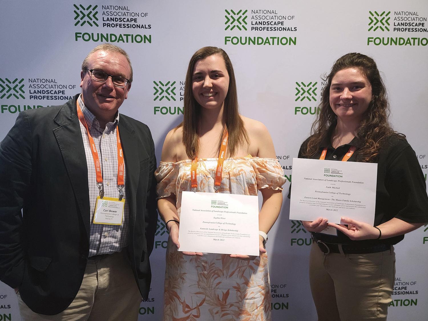 Penn College faculty member Carl J. Bower Jr. is joined by students Sophia Wiest and Faith Mitchell, who are holding certificates.