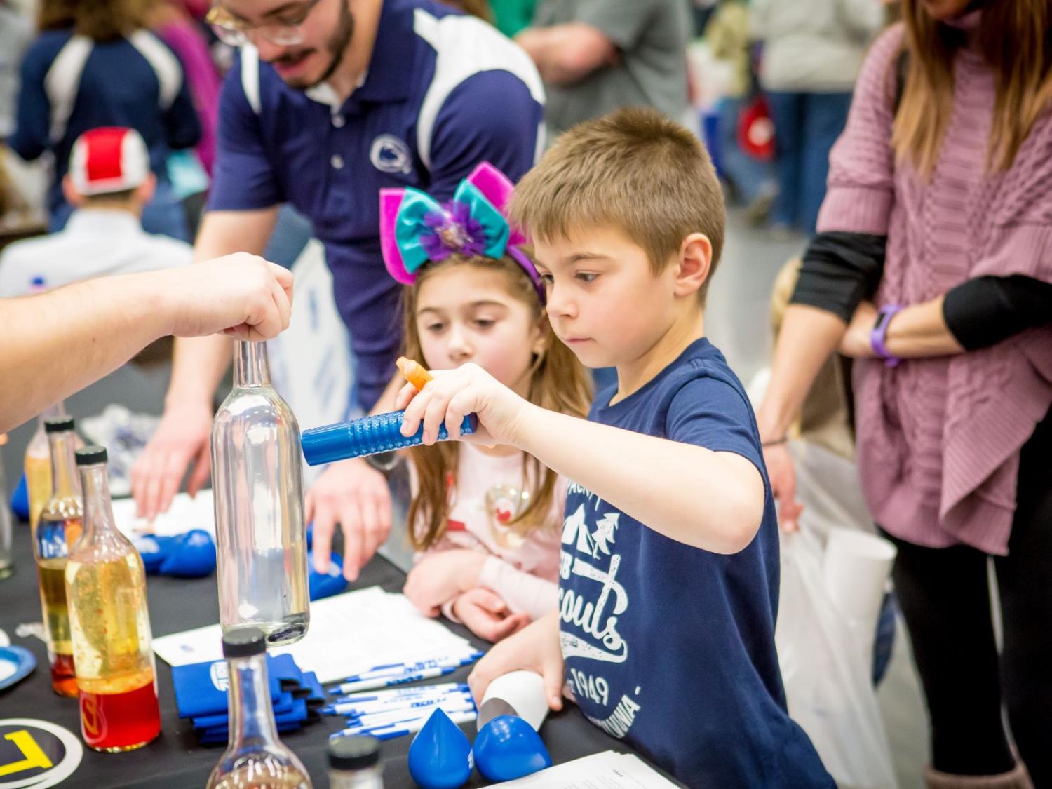 Two children play at a science table during the Penn State Behrend STEAM Fair in 2020.
