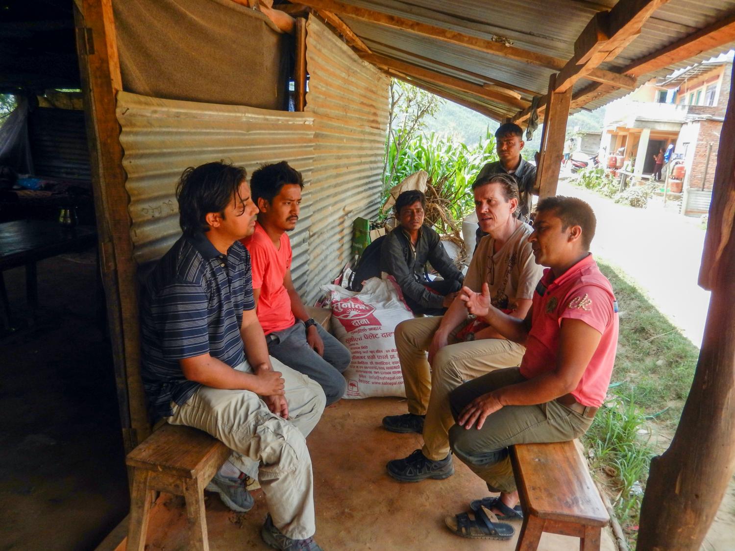 Christopher Scott (second from right, seated) and a doctoral student research the impacts of hydropower tradeoffs with farmer-managed irrigation systems by speaking with farmers in Nuwakot, Nepal.