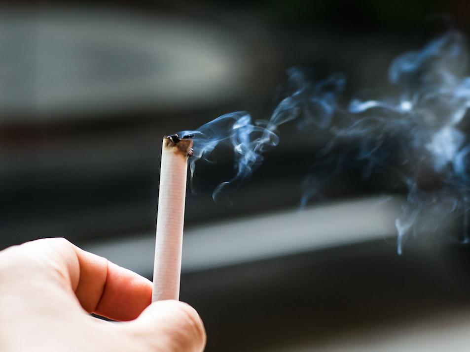 Cigarette burning in a person's hand