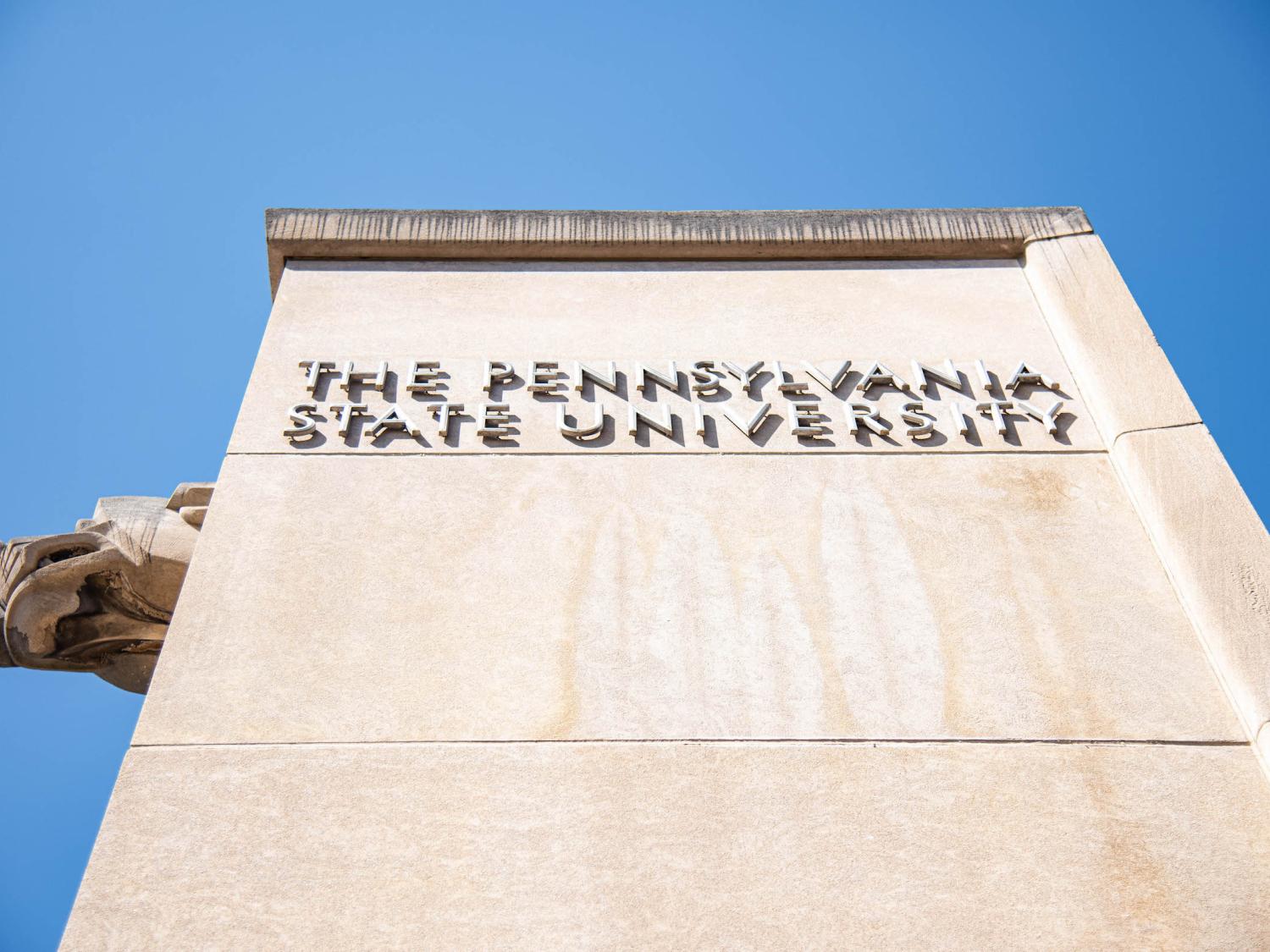 A stone column with the words "The Pennsylvania State University" against a blue sky