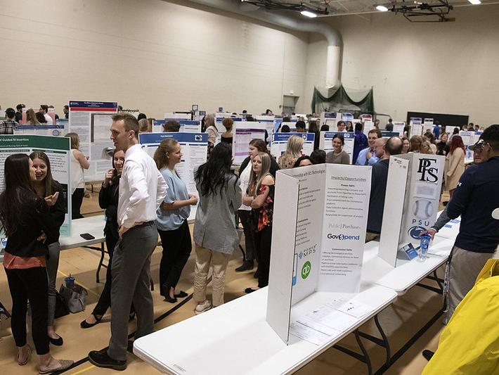 Students, faculty, and staff gather at the Spring 2022 Learning Fair in the auxiliary gym