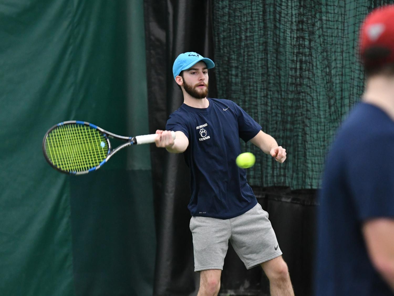 A Penn State Behrend tennis player hits a forehand shot.