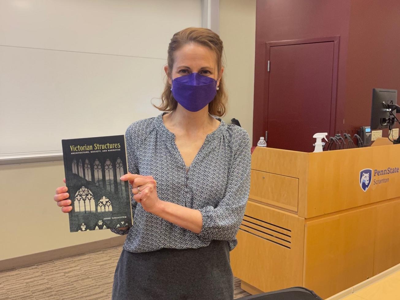 Jody Griffith holds up a copy of her first book, Victorian Structures