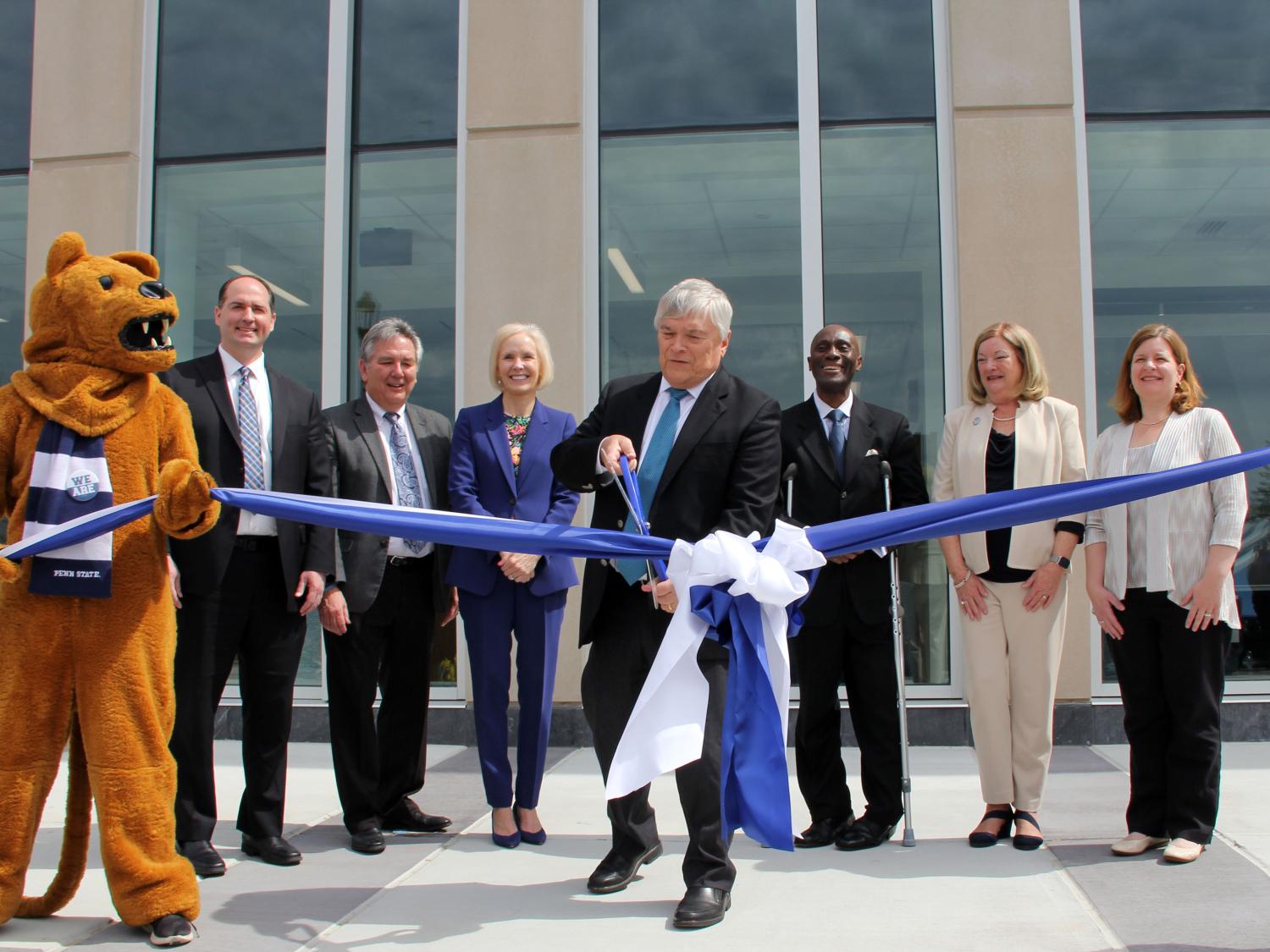 Individuals in front of Allied Health Building with mascot for ribbon cutting. 