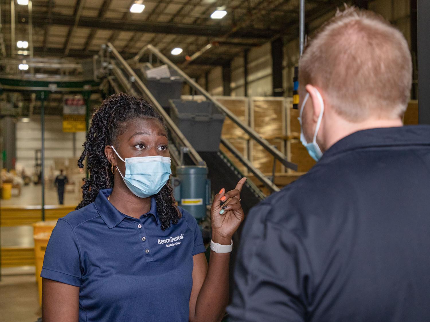 A Benco Dental employee talks to another employee.