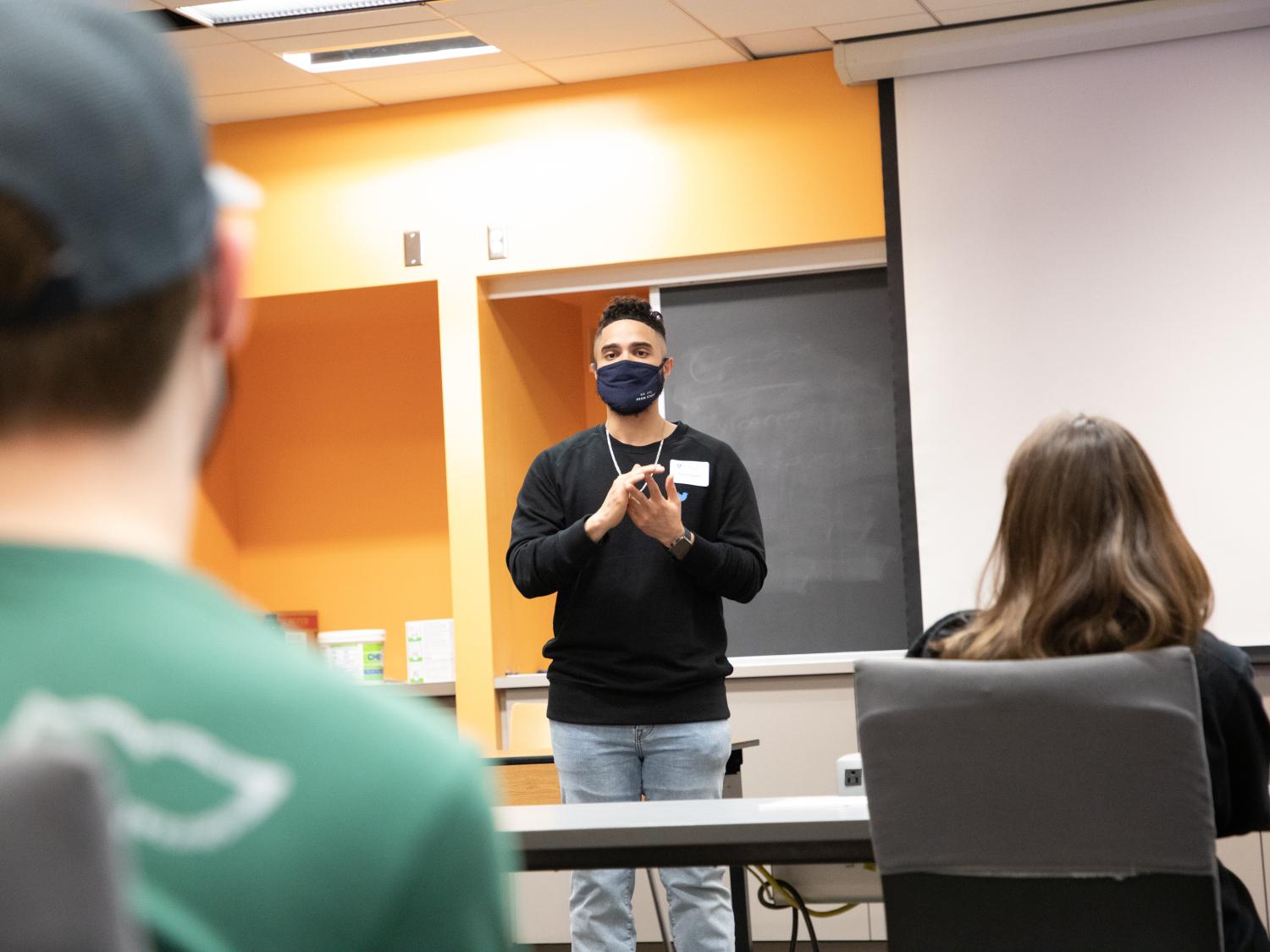 Noel Claudio speaks to a class of students.