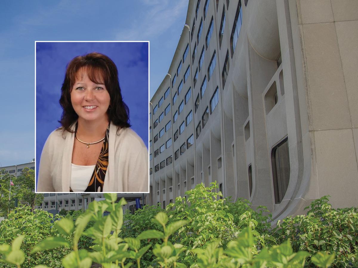 A head and shoulders professional portrait of Kelly Karpa against a background image of Penn State College of Medicine.