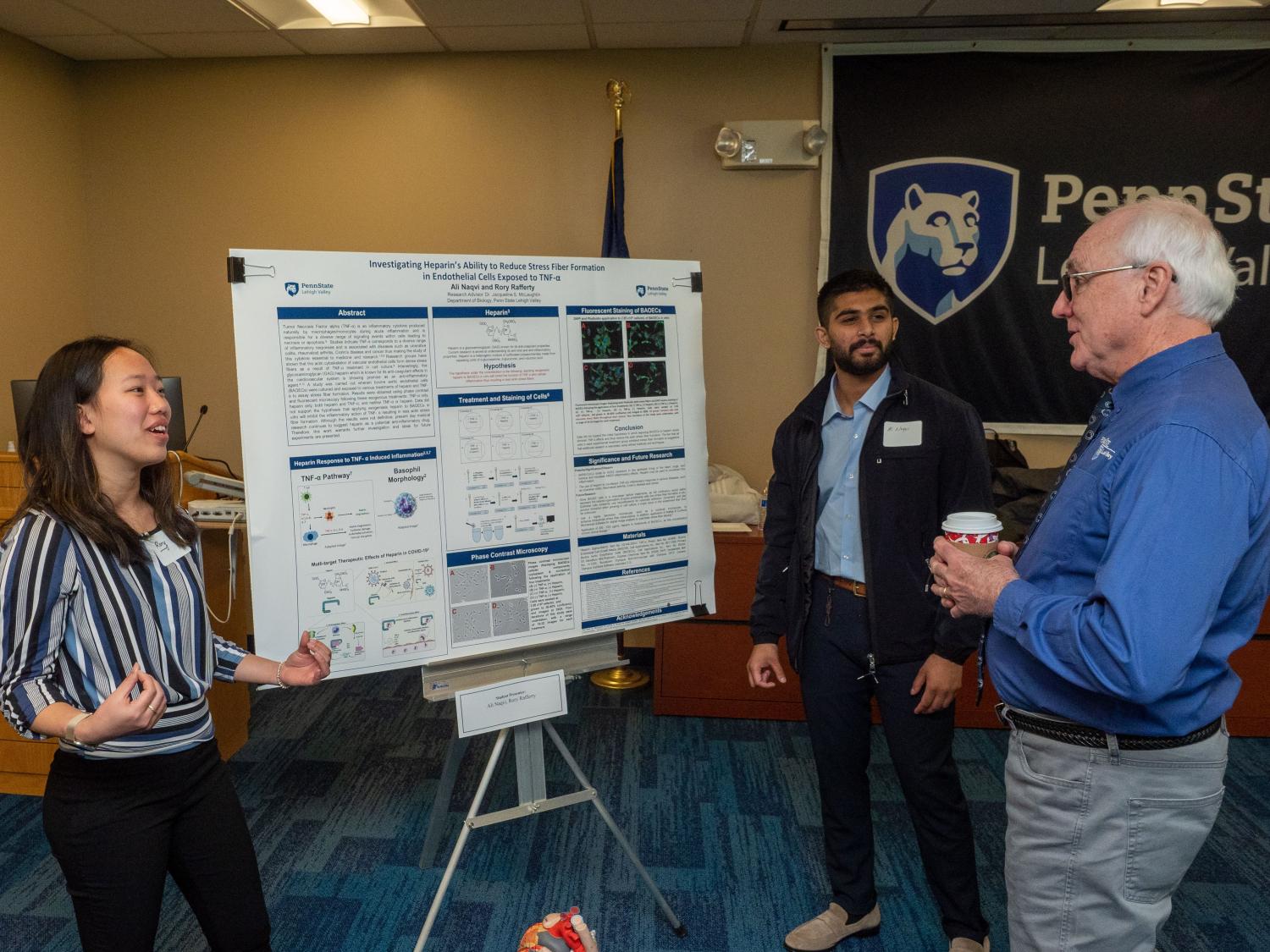 Students present research to faculty member 