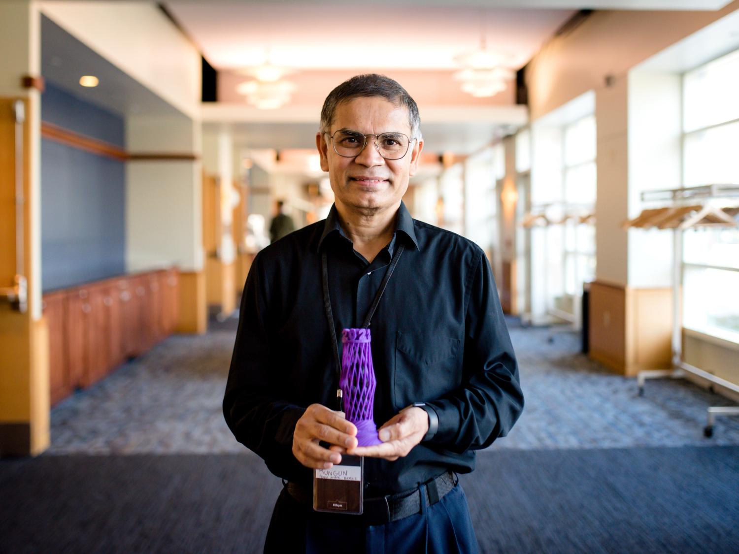 Rungun Nathan holds his award for winning the 2022 Open Innovation Challenge.