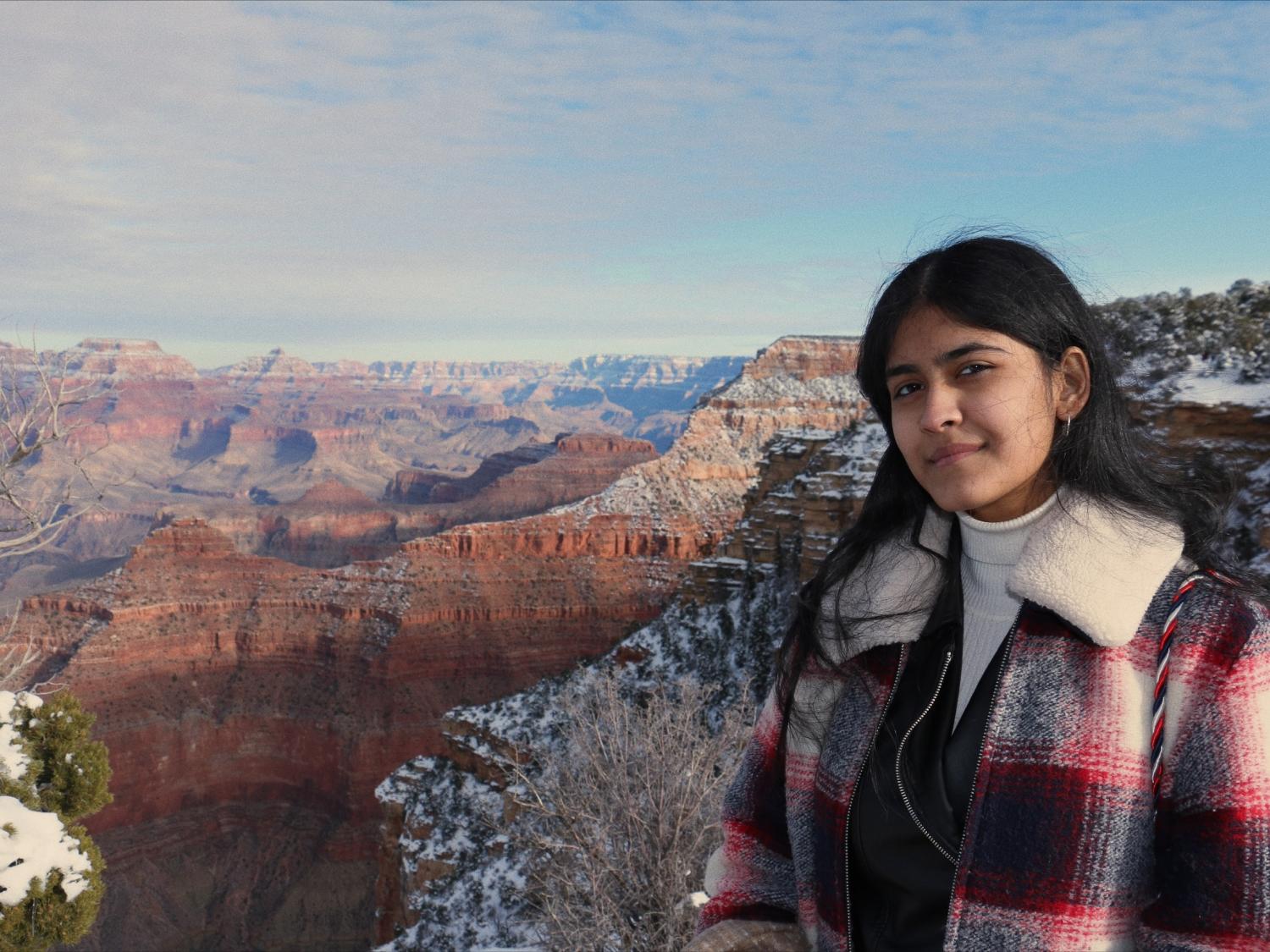 A female stands at the rim of the Grand Canyon.