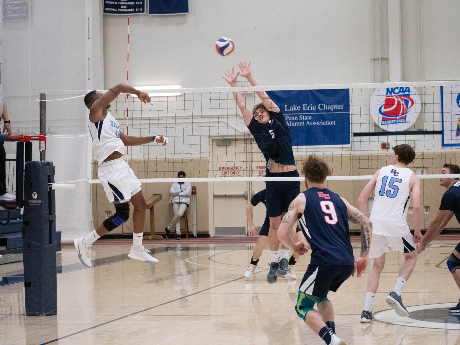 A Penn State Behrend volleyball player blocks a shot during a game.