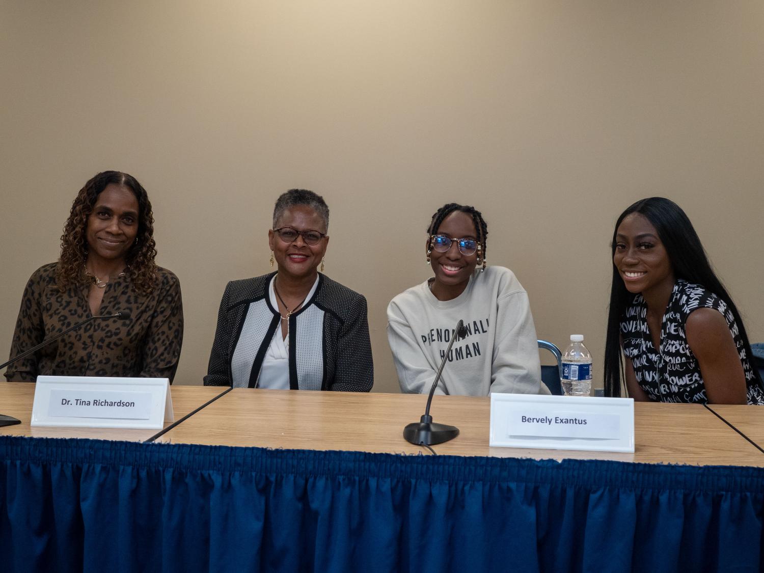 Panelists pose for pictures at table 