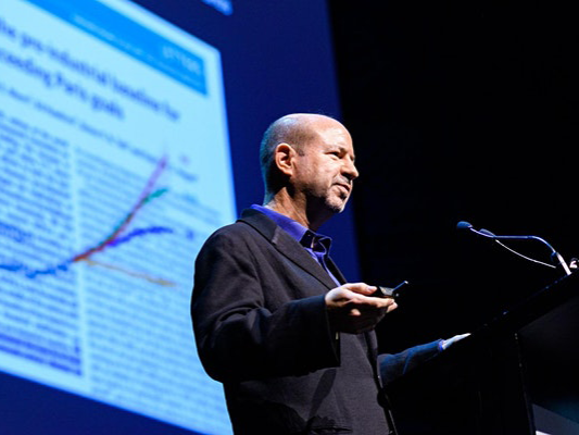 Michael Mann speaks in front of a screen