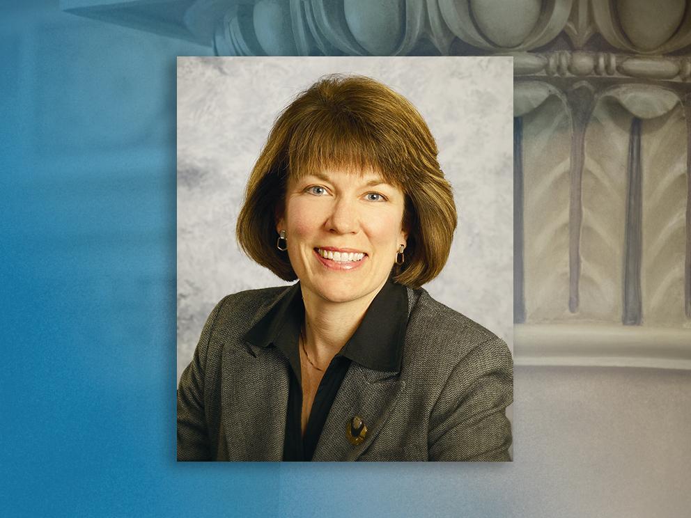 Portrait of a smiling woman on a blue and green background. 