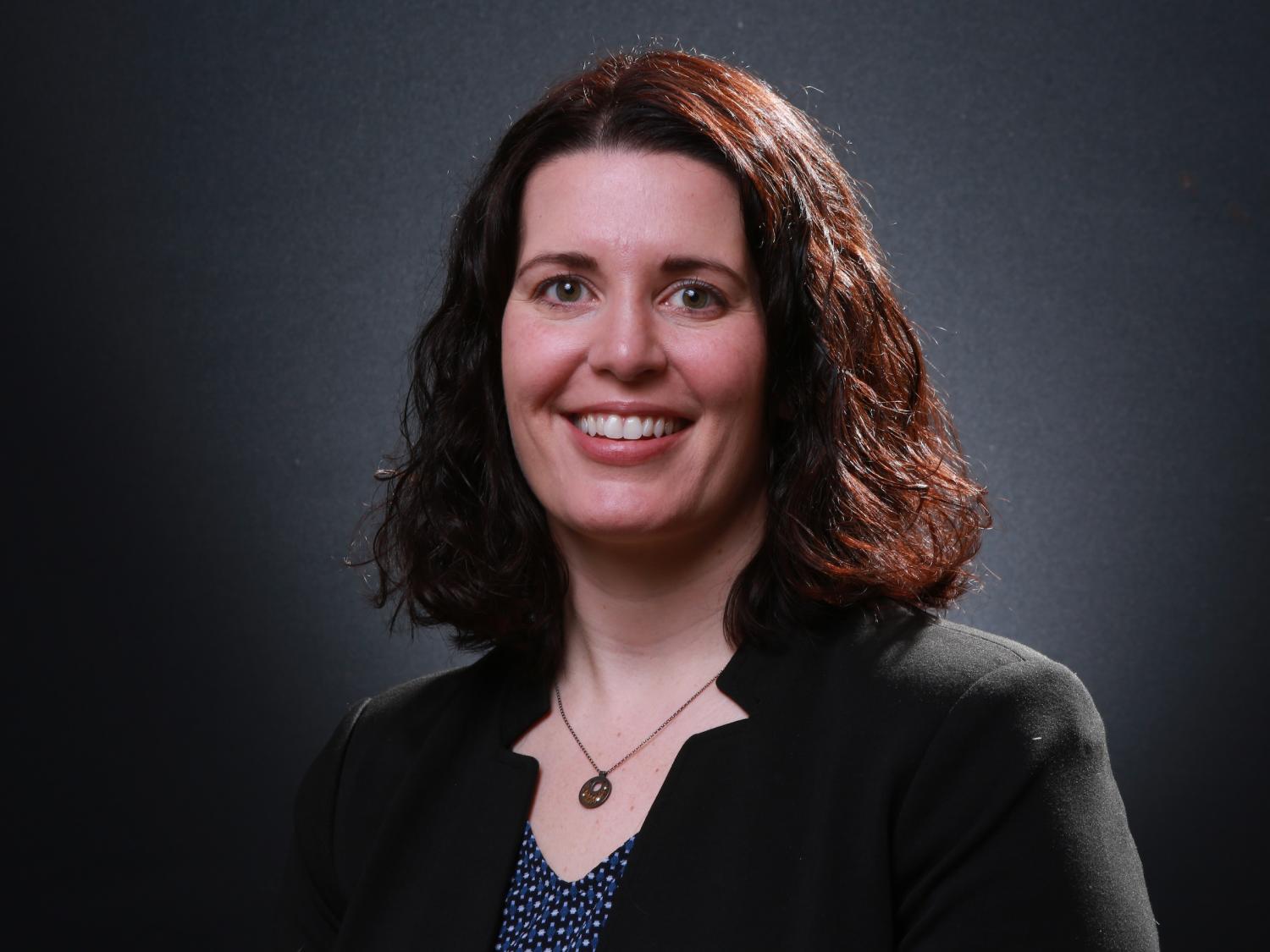 Kristin Wustholz headshot photo against a dark background