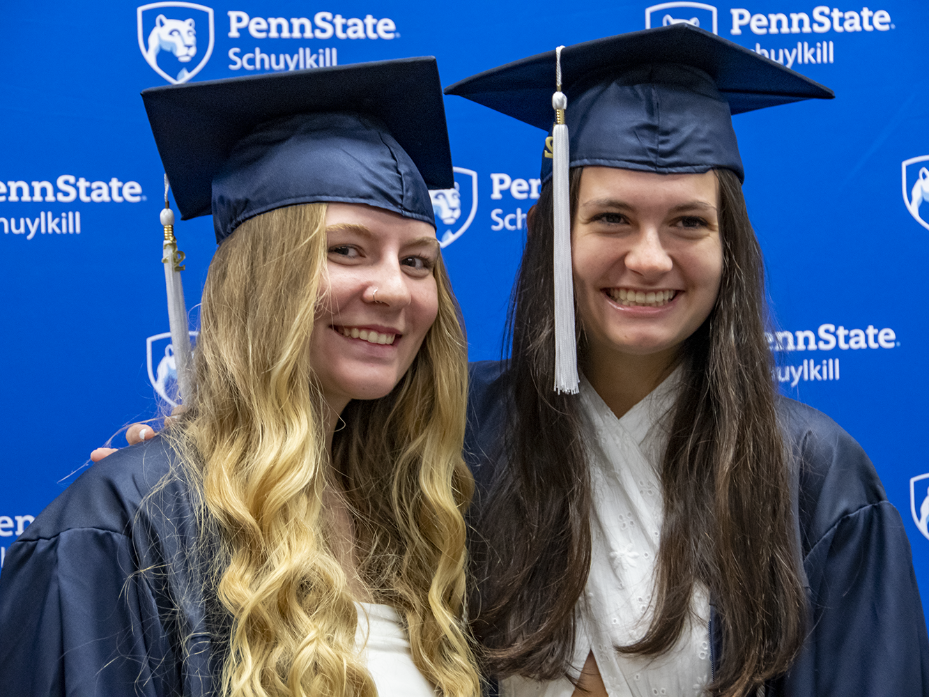 Two female students in graduation attire.