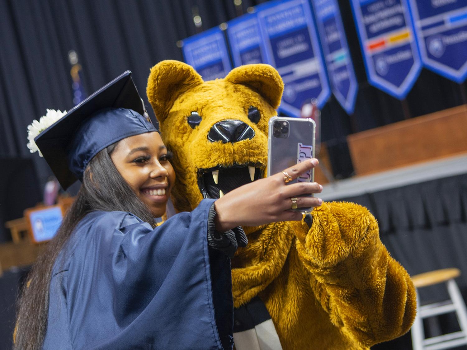 student taking selfie with Nittany Lion