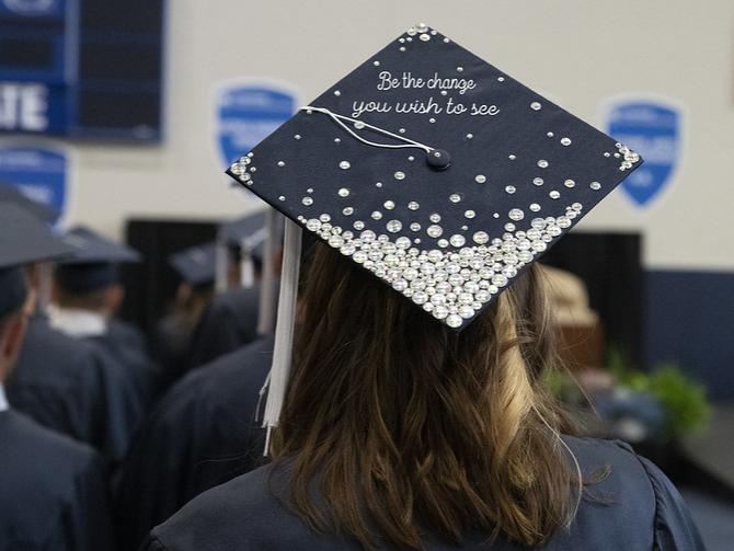 A graduation cap reads Be The Change You Wish to See