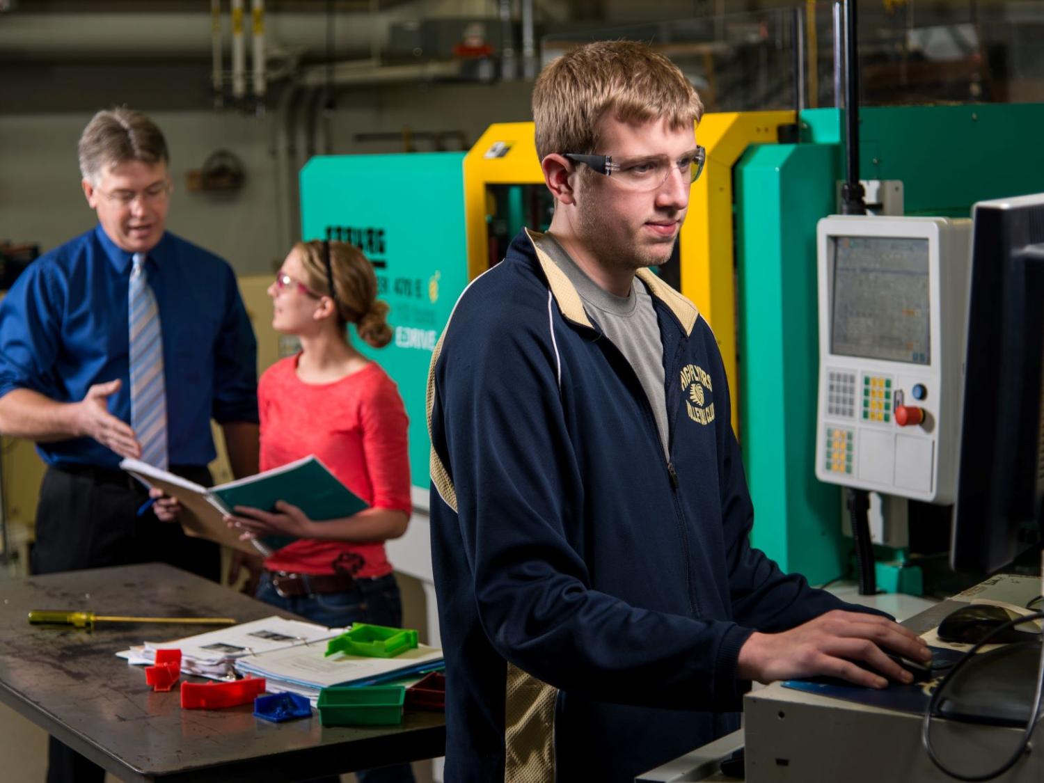 Two students and a faculty member work in Penn State Behrend's plastics engineering technology lab.