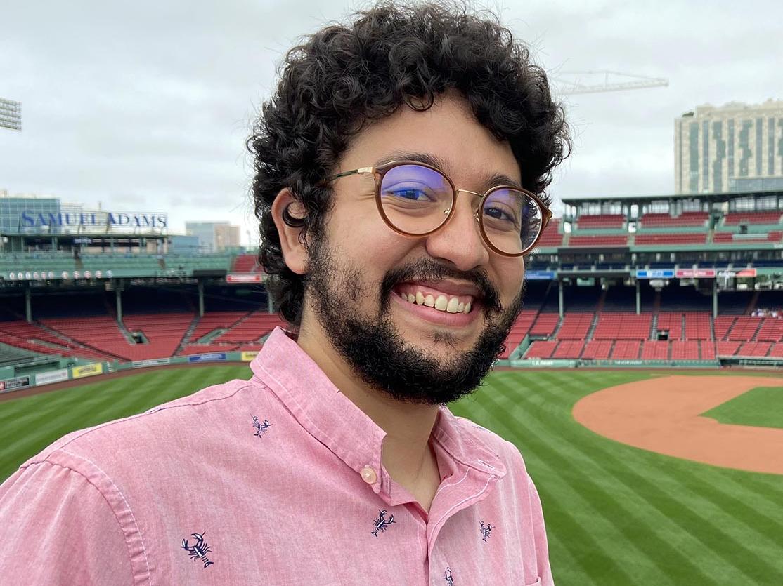 Man standing inside baseball stadium.