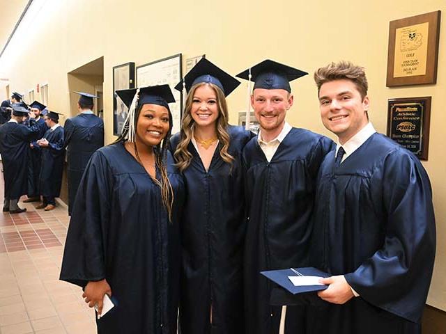 Four graduates standing together