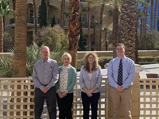 A group photo of three faculty members and one student
