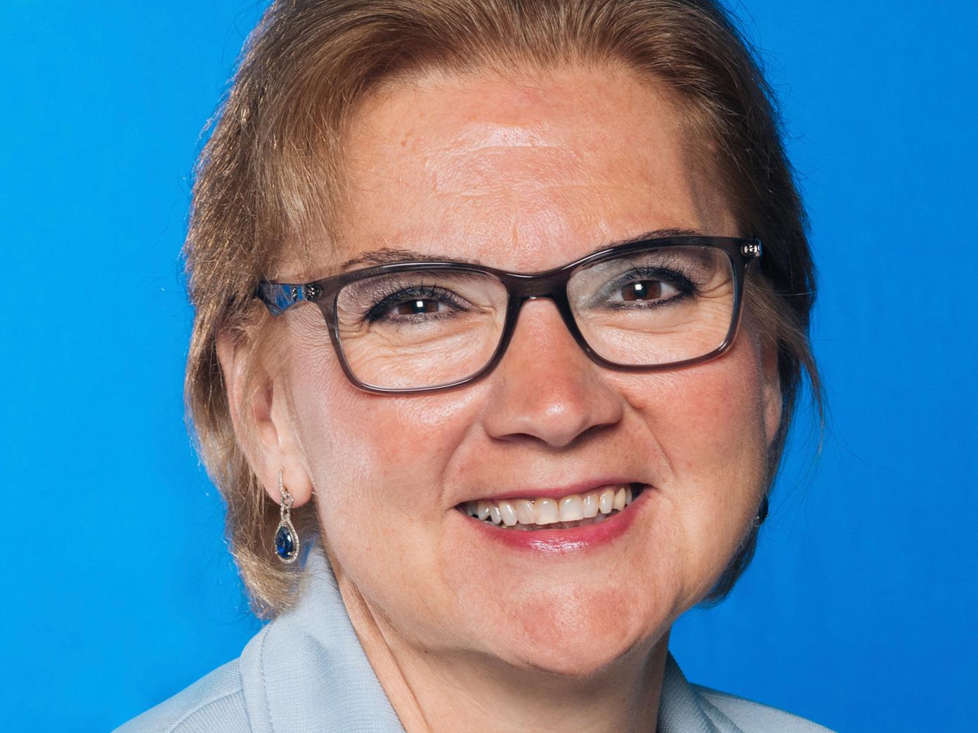 Headshot photo of Neslihan “Nesli” Alp against a blue background