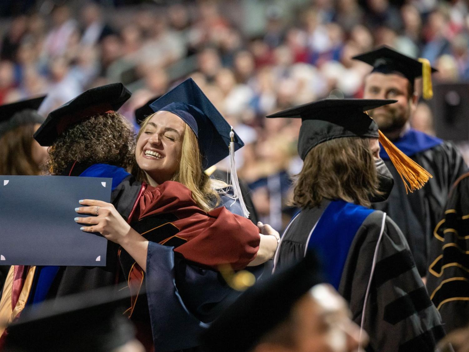 A student hugs a faculty member at Penn State Behrend's spring 2022 commencement program.
