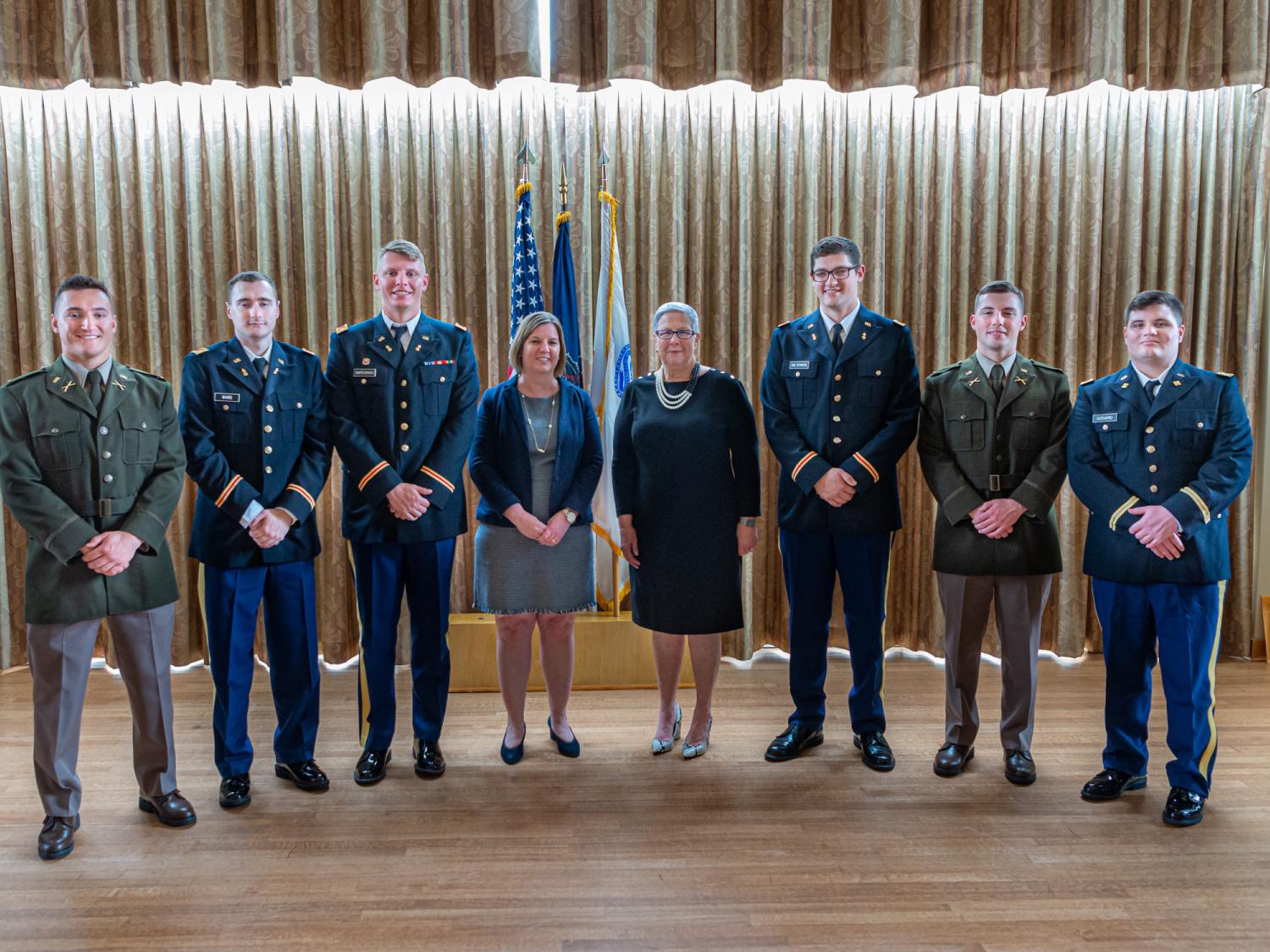 a group of graduates in Army uniforms posing for a photograph